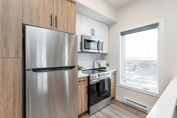 A modern kitchen with a stainless steel refrigerator and oven.